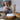 Woman adding essential oil to a wooden ultrasonic diffuser indoors.