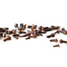 A scattered collection of whole, dark brown dried clove buds resting on a clean white surface.