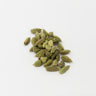 A small cluster of vibrant green whole cardamom pods scattered on a clean white surface.