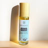 Megan & Co. Winter Warmer roll-on bottle on a wooden surface with a light background