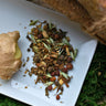 Megan & Co. Winter Warmer loose leaf herbal tea blend in a white glass plate, featuring warming cinnamon, ginger, and holy basil for seasonal wellness and improved circulation.