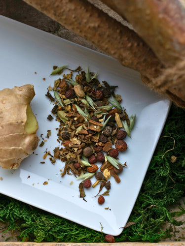 Megan & Co. Winter Warmer loose leaf herbal tea blend in a white glass plate, featuring warming cinnamon, ginger, and holy basil for seasonal wellness and improved circulation.
