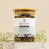 A glass jar containing loose leaf herbal tea blend with a label that reads 'MEGAN & CO. Women's Daily'.