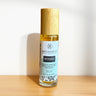 Roll-on bottle labeled 'Woods' by Megan & Co. on a wooden surface with a white background